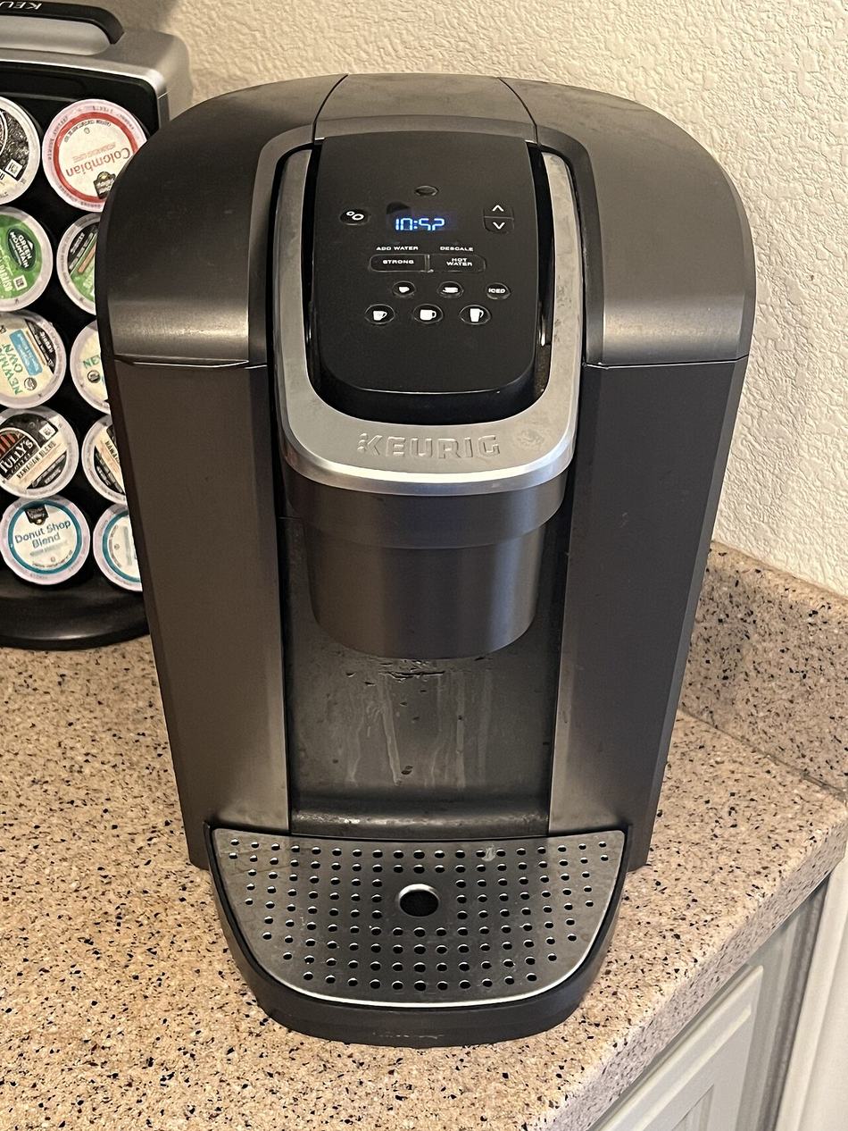 주방 조리대 위의 Keurig K-Elite 커피머신과 K-Cup 회전 거치대