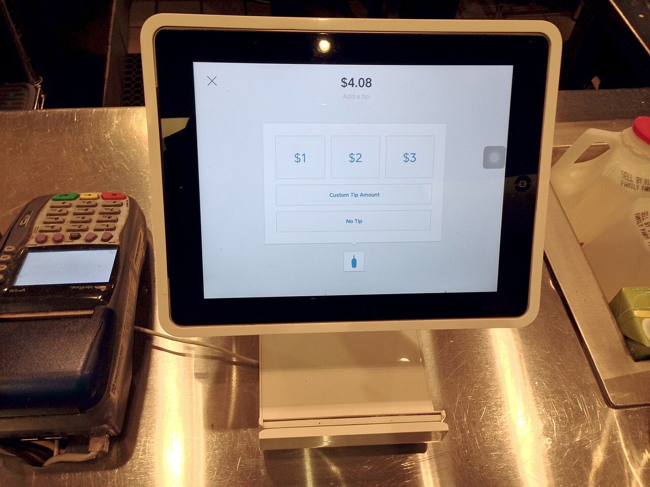 커피숍 카운터의 Square Stand — iPad를 POS로 바꾸고 하단에 카드리더가 붙어 있다