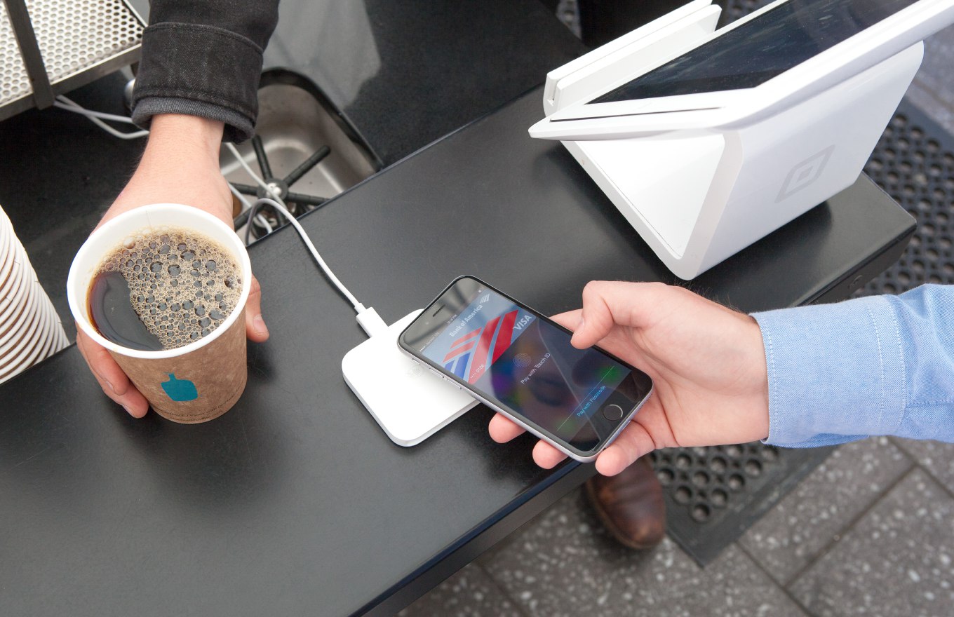 커피 매장에서 iPhone의 Apple Pay로 Square 비접촉 리더에 결제하는 장면